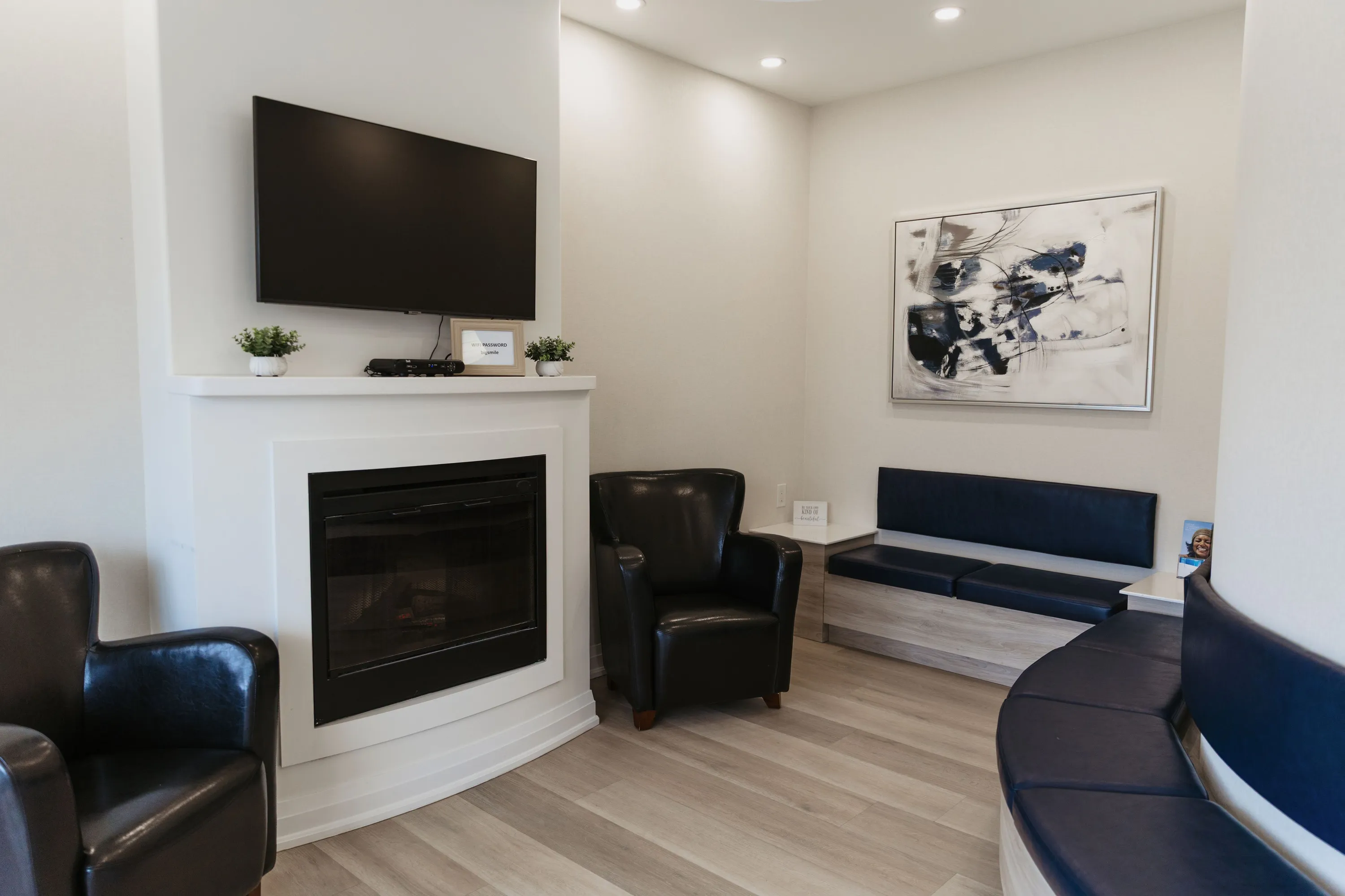 The Eastbridge Dental Care waiting room, with a warm fireplace and navy seating